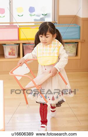 Stock Photo - Girl Carrying Chair. Fotosearch