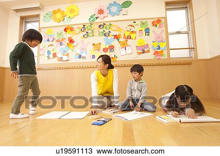 Nursery Teacher and Children Playing in a Room View Large Photo Image Stock Image - Nursery Teacher and Children Playing in a Room. Fotosearch