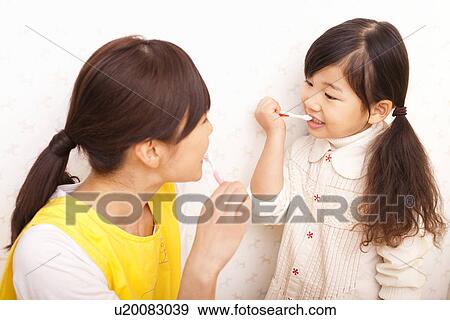 Nursery Teacher and Girl Brushing Teeth View Large Photo Image Stock Photo - Nursery Teacher and Girl Brushing Teeth. Fotosearch