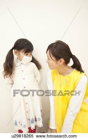 Stock Photography - Nursery Teacher and Girl Wearing Mask. Fotosearch