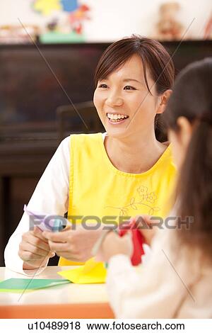 Nursery Teacher Teaching Origami View Large Photo Image Stock Photo - Nursery Teacher Teaching Origami. Fotosearch