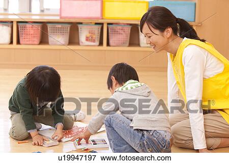 Stock Photo - Nursery Teacher Watching Children. Fotosearch