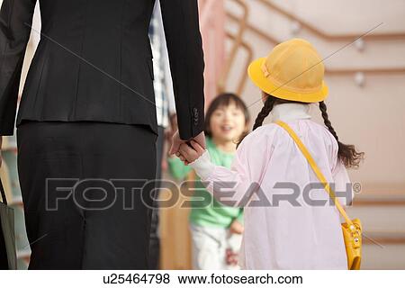 Stock Photo - Working Woman Dropping Daughter off Day-care Center. Fotosearch