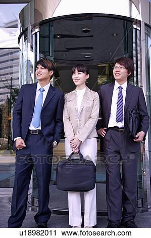 Three colleagues standing and looking away together with smile View Large Photo Image Stock Image - Three colleagues standing and looking away together with smile. Fotosearch