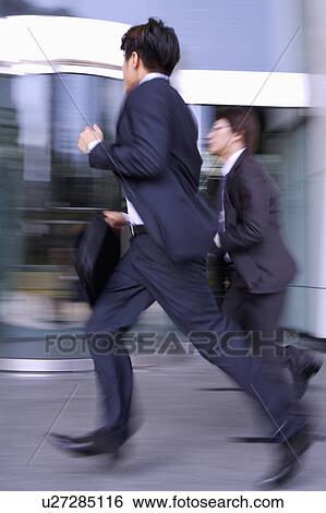 Two businessmen running together View Large Photo Image Stock Photograph - Two businessmen running together. Fotosearch