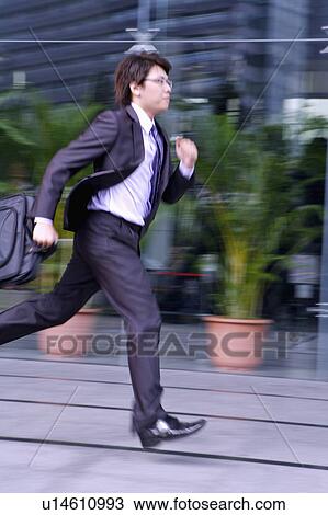 Young businessman holding briefcase and running fast View Large Photo Image Stock Image - Young businessman holding briefcase and running fast. Fotosearch