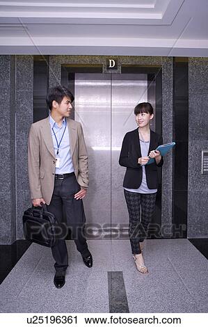 Young man and woman walking before elevator and talking together View Large Photo Image Stock Image - Young man and woman walking before elevator and talking together. Fotosearch