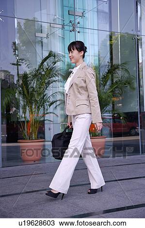 Young woman holding briefcase and walking View Large Photo Image Stock Image - Young woman holding briefcase and walking. Fotosearch