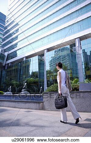Young woman holding briefcase and walking View Large Photo Image Stock Photograph - Young woman holding briefcase and walking. Fotosearch