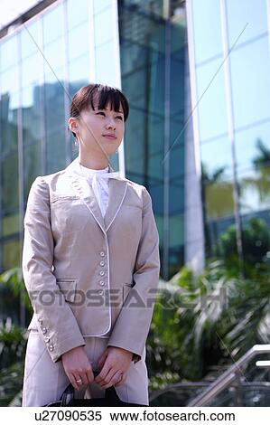 Young woman holding briefcase and looking away with anticipation View Large Photo Image Stock Photography - Young woman holding briefcase and looking away with anticipation. Fotosearch