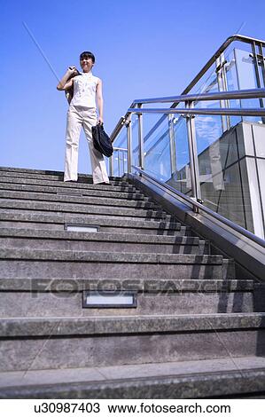 Young woman standing on steps and holding briefcase View Large Photo Image Stock Image - Young woman standing on steps and holding briefcase. Fotosearch