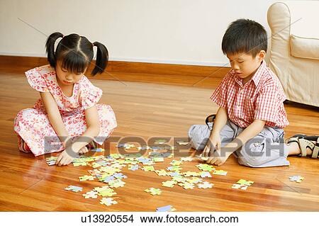 Picture - Boy playing with a jigsaw puzzle. Fotosearch