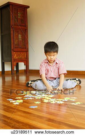 Boy playing with a jigsaw puzzle View Large Photo Image Stock Image - Boy playing with a jigsaw puzzle. Fotosearch
