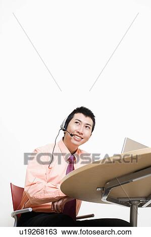 Stock Image - Businessman wearing headset and smiling. Fotosearch