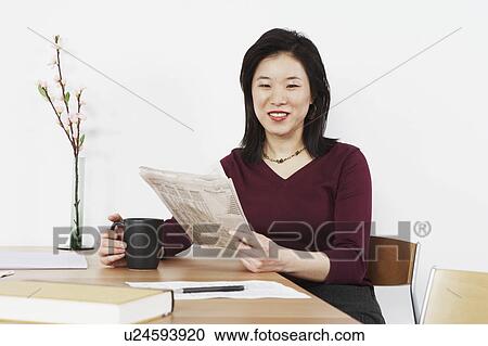 Businesswoman holding a newspaper View Large Photo Image Stock Image - Businesswoman holding a newspaper. Fotosearch