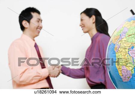 Picture - Businesswoman shaking hands with a businessman. Fotosearch