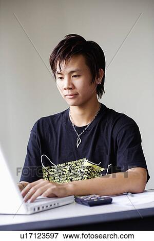 Stock Photo - Close-up of a boy using a laptop. Fotosearch