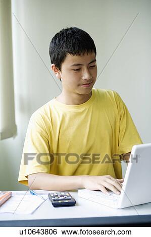 Close-up of a boy using a laptop View Large Photo Image Stock Photograph - Close-up of a boy using a laptop. Fotosearch