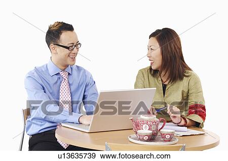 Close-up of a businessman and a businesswoman in front of a laptop View Large Photo Image Stock Photo - Close-up of a businessman and a businesswoman in front of a laptop. Fotosearch