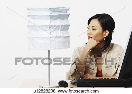Close-up of a businesswoman sitting in front of a computer View Large Photo Image Stock Photo - Close-up of a businesswoman sitting in front of a computer. Fotosearch