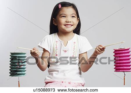 Close-up of a girl holding two Chinese lanterns and smiling View Large Photo Image Stock Image - Close-up of a girl holding two Chinese lanterns and smiling. Fotosearch