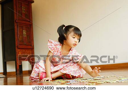 Stock Image - Close-up of a girl sitting on the floor. Fotosearch