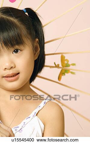 Stock Image - Close-up of a girl with a parasol. Fotosearch