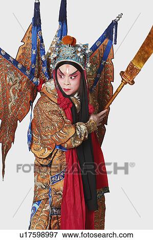 Stock Photo - Close-up of a male Chinese opera performer holding a weapon. Fotosearch