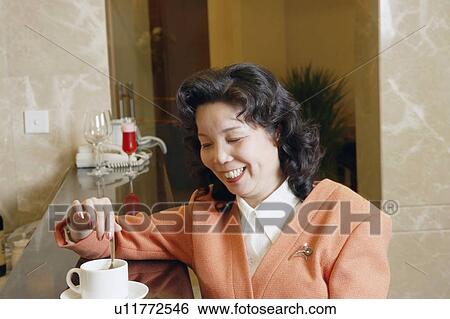 Close-up of a mature woman stirring a cup of coffee View Large Photo Image Stock Photograph - Close-up of a mature woman stirring a cup of coffee. Fotosearch