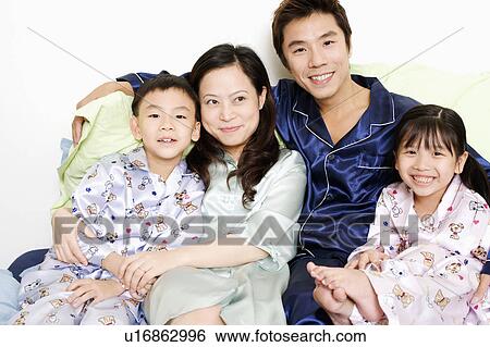 Close-up of a mid adult man and a young woman smiling with their children View Large Photo Image Stock Photograph - Close-up of a mid adult man and a young woman smiling with their children. Fotosearch