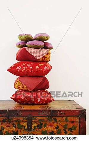 Picture - Close-up of a stack of cushions on a trunk. Fotosearch