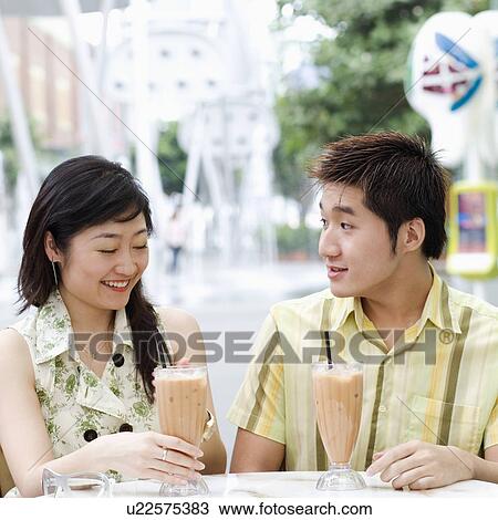 Stock Image - Close-up of a young couple sitting in a cafeteria. Fotosearch