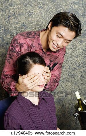 Close-up of a young man covering a young woman's eyes with his hands View Large Photo Image Stock Photography - Close-up of a young man covering a young woman's eyes with his hands. Fotosearch