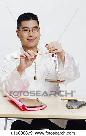 Stock Photo - Close-up of a young man using a balance scale. Fotosearch