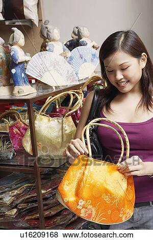 Close-up of a young woman choosing a hand bag View Large Photo Image Stock Photo - Close-up of a young woman choosing a hand bag. Fotosearch