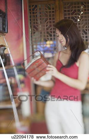 Close-up of a young woman holding a box View Large Photo Image Stock Photo - Close-up of a young woman holding a box. Fotosearch