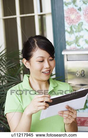 Close-up of a young woman reading a mail View Large Photo Image Stock Photography - Close-up of a young woman reading a mail. Fotosearch