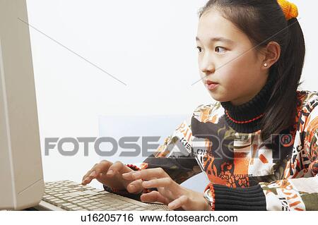 Close-up of a young woman using a computer View Large Photo Image Stock Photograph - Close-up of a young woman using a computer. Fotosearch