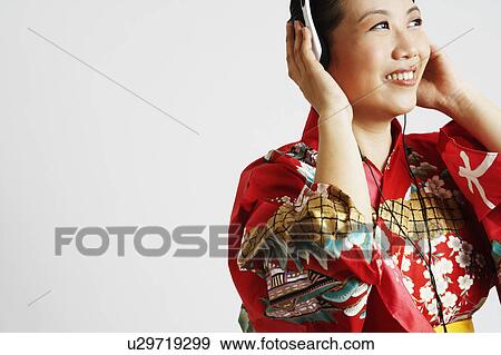 Stock Photo - Close-up of a young woman wearing headphones and listening to music. Fotosearch
