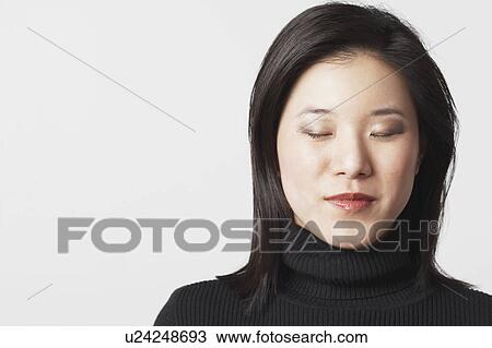 Stock Image - Close-up of a young woman with her eyes closed. Fotosearch