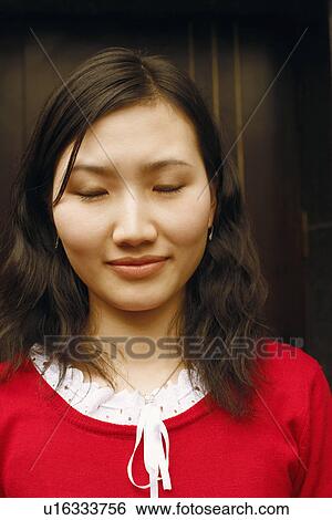 Close-up of a young woman with her eyes closed View Large Photo Image Stock Photograph - Close-up of a young woman with her eyes closed. Fotosearch