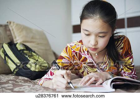 Close-up of a young woman writing in a notebook View Large Photo Image Stock Image - Close-up of a young woman writing in a notebook. Fotosearch