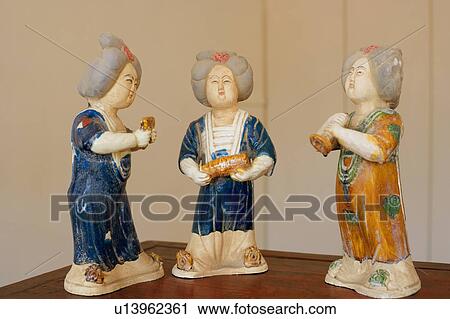 Stock Image - Close-up of three figurines on a table. Fotosearch