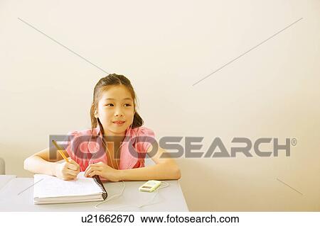 Girl listening to an MP3 player and holding a pen on a spiral notebook View Large Photo Image Stock Image - Girl listening to an MP3 player and holding a pen on a spiral notebook. Fotosearch
