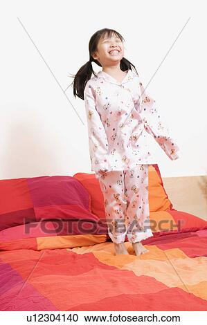 Girl standing on the bed View Large Photo Image Stock Image - Girl standing on the bed. Fotosearch