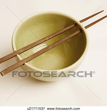 Stock Photo - High angle view of a bowl and two chopsticks. Fotosearch