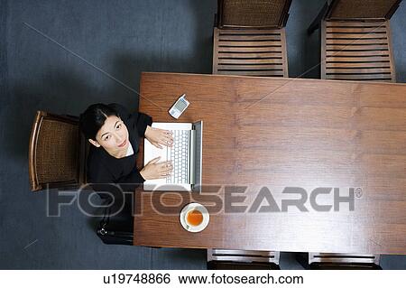 High angle view of a businesswoman using a laptop View Large Photo Image Stock Photograph - High angle view of a businesswoman using a laptop. Fotosearch