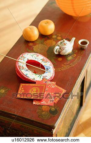 Stock Photograph - High angle view of a Chinese lantern and a kettle with envelopes on the table. Fotosearch