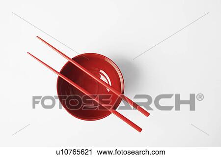 Stock Image - High angle view of a pair of chopsticks on a bowl. Fotosearch