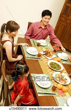 High angle view of a young couple sitting at the table with their daughter View Large Photo Image Stock Image - High angle view of a young couple sitting at the table with their daughter. Fotosearch